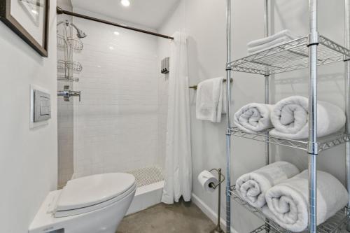 a white bathroom with a toilet and towels at Warehouse District Intimate One Bedroom in New Orleans