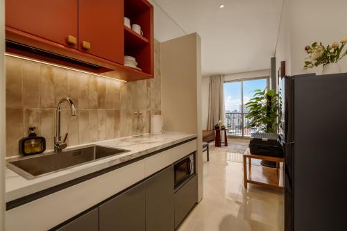a kitchen with a sink and a refrigerator at Amber Bay Hotel & Suites Da Nang in Danang