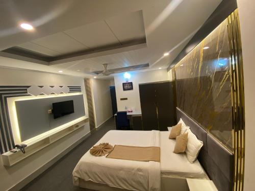 a hotel room with a bed and a television at Hotel Grand Mafi, Sylhet in Boāli