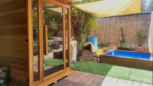 a small garden with a pool in a backyard at Jordan River Village in Menaẖemya