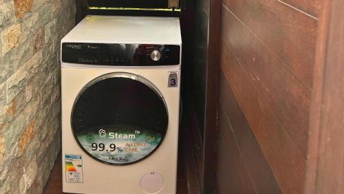 a washing machine sitting next to a brick wall at TAHITI - Fare Matovai in Aua
