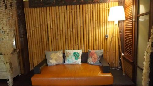 a couch with four pillows on it in a room at TAHITI - Fare Matovai in Aua