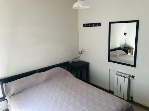 ein Schlafzimmer mit einem Bett und einem Spiegel in der Unterkunft DPto Carlos Paz in Villa Carlos Paz