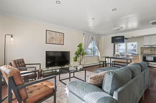 a living room with a couch and a tv at Group Chic - 25 Mins to NYC - FREE Parking - Washer & Dryer in Fairview