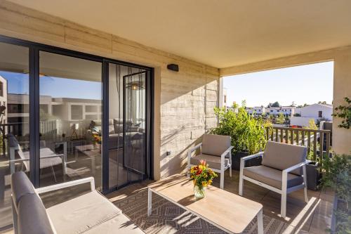 a patio with chairs and a table on a balcony at FLORA -T2 46 m2 - terrasse in Mauguio