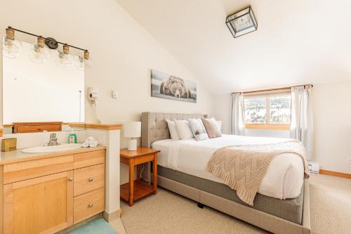 a bedroom with a bed and a sink at Downtown Delight - Penthouse with Shared Rooftop Hot Tub in Canmore