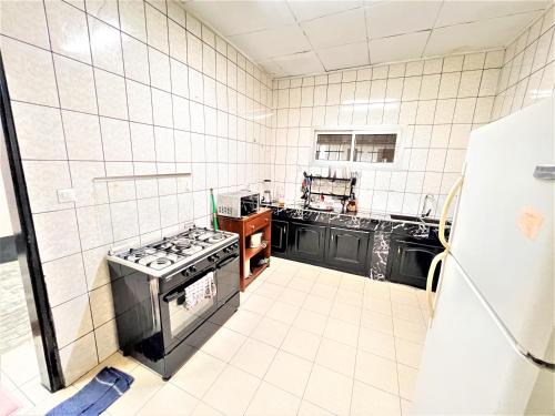 a kitchen with a stove and a refrigerator at The Yafé Bastos 15 (Villa) in Yaoundé