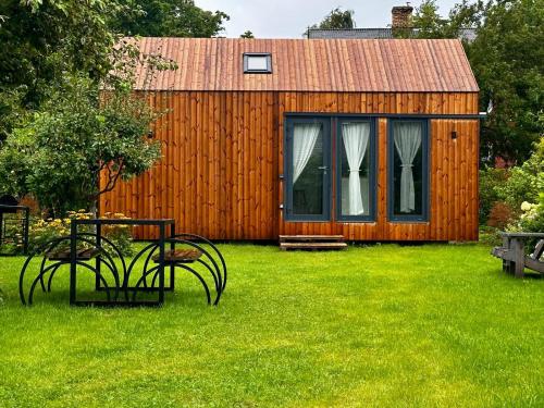 a wooden shed with a table and chairs in a yard at Namiņš atpūtai in Liepāja