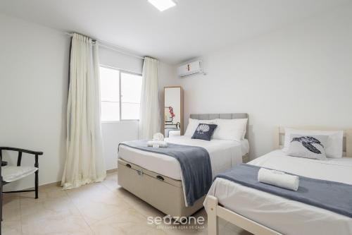 a bedroom with two beds and a window at Apto c/ Churrasqueira a 230 m da Praia SHA0104 in Piçarras