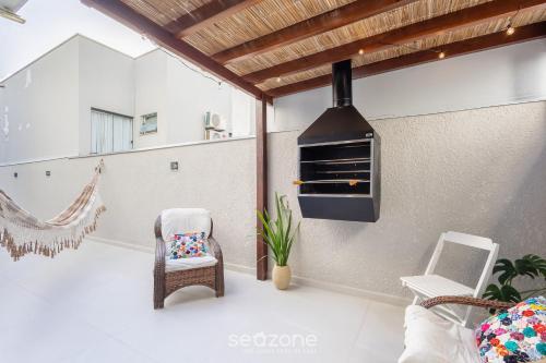 a patio with a stove and a chair and a hammock at Apto c/ Churrasqueira a 230 m da Praia SHA0104 in Piçarras