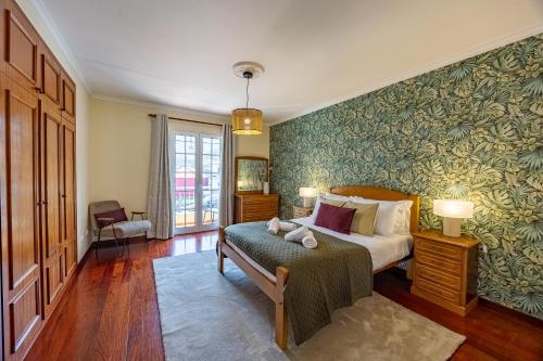 ein Schlafzimmer mit einem Bett und einer grünen Wand in der Unterkunft Casa Golino by YOUR KEY in São Vicente