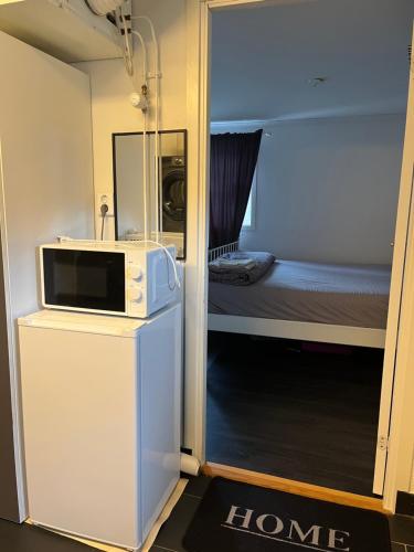 a room with a microwave and a room with a bed at Guest suite Sandviken in Sandviken