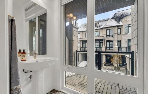 a bathroom with a sink and a window with a view at Entire place in Richmond hill Modern Luxury Home in Richmond Hill