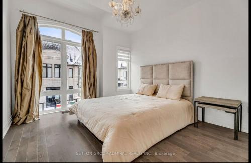 a white bedroom with a large bed and a window at Entire place in Richmond hill Modern Luxury Home in Richmond Hill