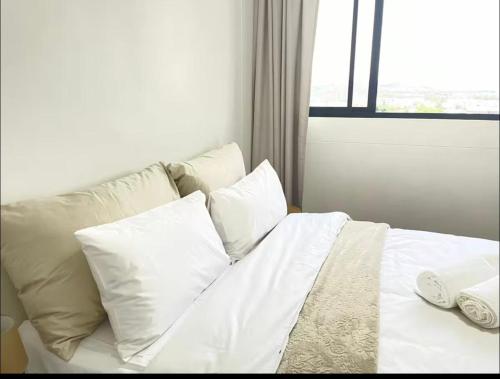 a white bed with white pillows and a window at ProAvia Apartments and Hotel in Windhoek