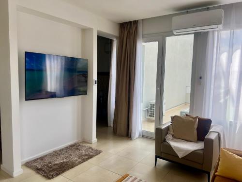a living room with a chair and a large window at Bahía Loft Nordelta 221 in Benavídez