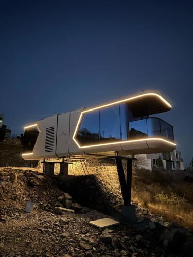 a house with lights on it sitting on the beach at Capsule Mountain 