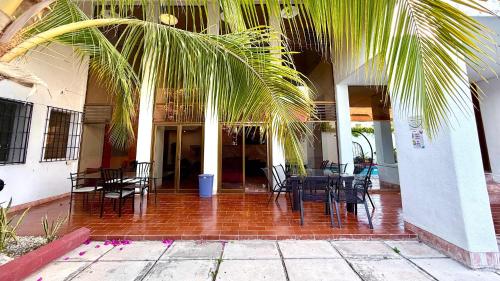 a patio with tables and chairs and a palm tree at Incredible Loft with pool in Chuburná de Hidalgo