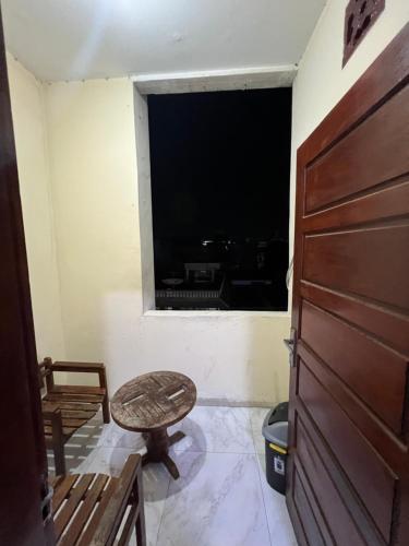 a room with a window and a chair and a door at Hotel De kock BnB in Bukittinggi