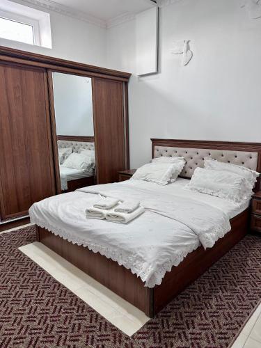 a bedroom with a large bed with two towels on it at The Homely Stay in Bukhara