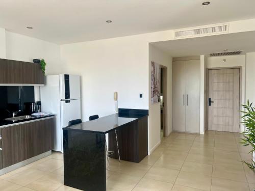 a kitchen with a black counter and a refrigerator at Bahía Loft Nordelta 221 in Benavídez