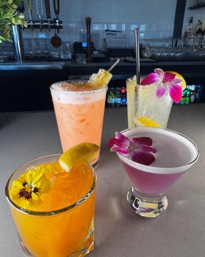 two cocktails on a table with a bowl of flowers at Four Points by Sheraton Norwood Conference Center in Norwood