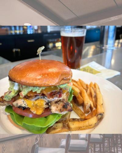 a hamburger and french fries on a plate with a drink at Four Points by Sheraton Norwood Conference Center in Norwood
