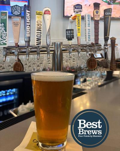 a glass of beer sitting on top of a bar at Four Points by Sheraton Norwood Conference Center in Norwood
