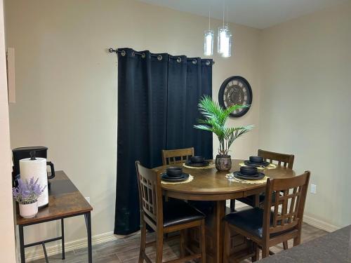 a dining room table and chairs with a dark blue curtain at Quiet 2BR Retreat , Fenced yard , Modern Duplex in Harlingen