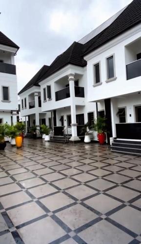 a building with a tiled courtyard with potted plants at Bespoke Terraces in Benin City