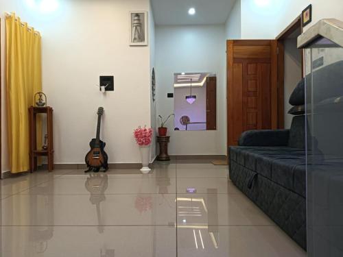 a living room with a couch and a guitar at Pepper Jazz Varkala in Varkala