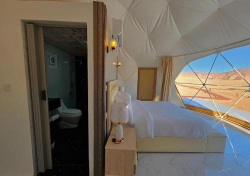 a bedroom with a bed and a view of the desert at Catalina Luxury rum camp in Wadi Rum