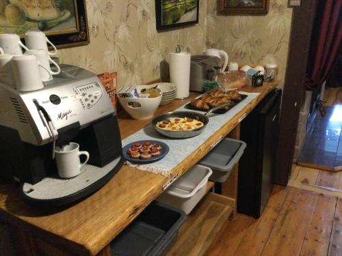 een aanrecht met een koffiezetapparaat en een bord met eten bij Ferme Jardin Potager in Sainte-Rose-du-Nord