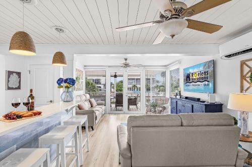 a living room with a couch and a ceiling fan at Boating Enthusiasts, Walk to the Beach, Heated Pool - The Corner cottage - Roelens in Fort Myers Beach