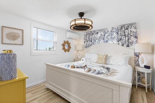 a bedroom with a white bed and a window at Boating Enthusiasts, Walk to the Beach, Heated Pool - The Corner cottage - Roelens in Fort Myers Beach