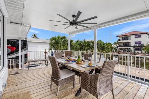 a patio with a table and chairs on a deck at Boating Enthusiasts, Walk to the Beach, Heated Pool - The Corner cottage - Roelens in Fort Myers Beach