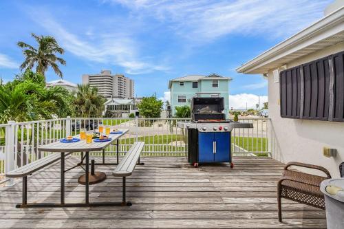 a patio with a table and a grill on a deck at Boating Enthusiasts, Walk to the Beach, Heated Pool - The Corner cottage - Roelens in Fort Myers Beach