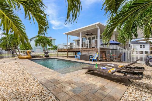 a backyard with a swimming pool and a house at Boating Enthusiasts, Walk to the Beach, Heated Pool - The Corner cottage - Roelens in Fort Myers Beach