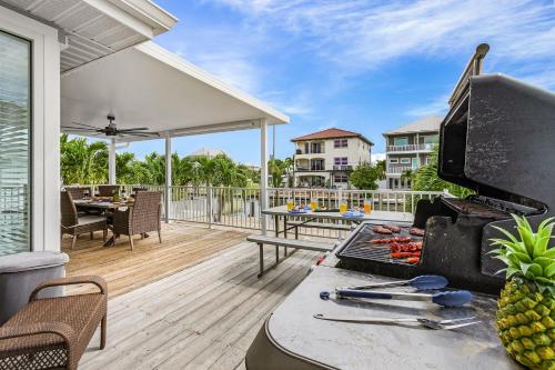 a patio with a grill and a table on a deck at Boating Enthusiasts, Walk to the Beach, Heated Pool - The Corner cottage - Roelens in Fort Myers Beach