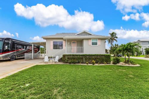 a house with a bus parked in a yard at Boating Enthusiasts, Walk to the Beach, Heated Pool - The Corner cottage - Roelens in Fort Myers Beach