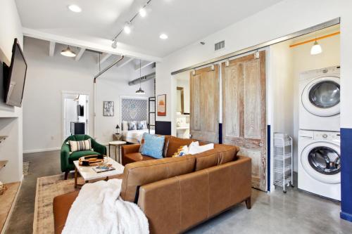 a living room with a couch and a washer and dryer at Warehouse District Lovely One Bedroom and Den in New Orleans