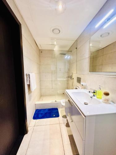 a bathroom with a white sink and a shower at RDA 1bedroom at The Signature Apartment in Accra