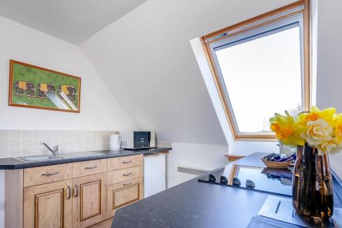 a kitchen with a vase of yellow flowers on a counter at Vorlich in Methven