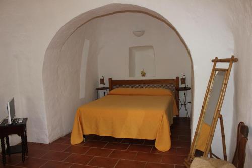 a bedroom with a bed with an orange blanket at Masseria Vagone in Macchia di Monte