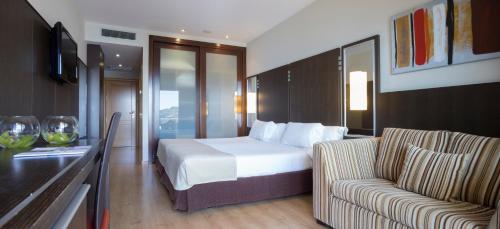 a hotel room with a bed and a couch at Gran Talaso Hotel Sanxenxo in Sanxenxo