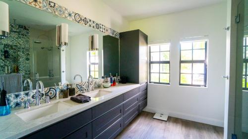 a bathroom with two sinks and a large mirror at Villa Viscayne - Miami Modern Luxury with Pool & Spa in Biscayne Park