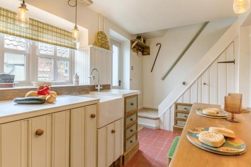a kitchen with white cabinets and a wooden table at 2 Bed in Colkirk oc-j33005 in Colkirk
