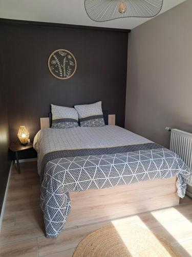 a bedroom with a bed with a blue and white comforter at LE NATURE Centre ville 2 Chambres in Colmar