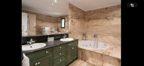 Un baño con dos lavabos y una bañera. en Torrent Veda Chalet, en Torrent