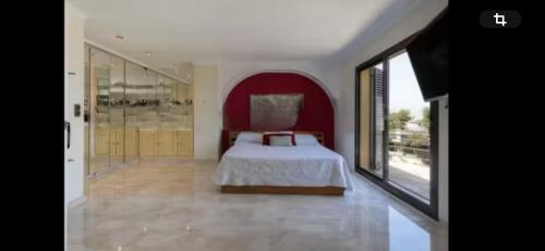 Un dormitorio con una cama y una ventana grande. en Torrent Veda Chalet, en Torrent